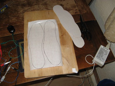 Tracing the insoles onto sticky-backed plastic