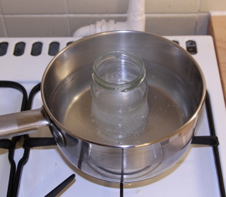 The jar of NaOH in a saucepan of hot water
